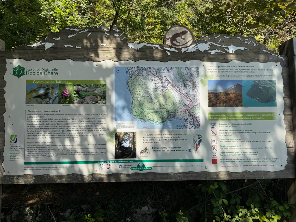 Informationstafel im Wald zum Naturschutzgebiet „Réserve Naturelle Roc de Chère“ mit Karte, Fotos und Verhaltensregeln.